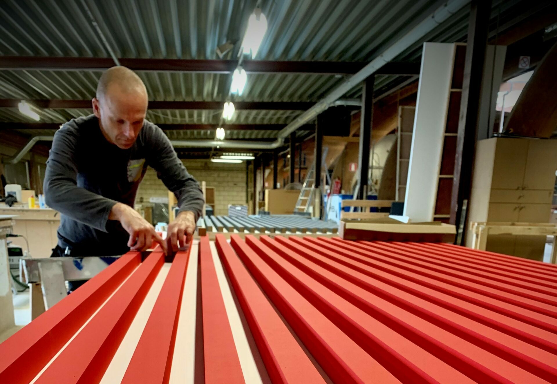 Een standenbouwer aan het werk aan een pop-up shop element in het atelier van Expo Z in Westmalle standenbouwer in atelier Expo Z aan het werk aan pop-up shop