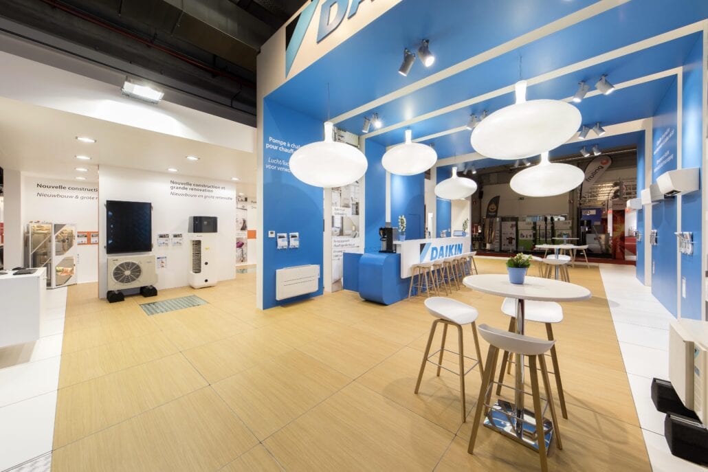 De verhoogde houten vloer zorgt voor een gezellig interieur hier op de beursstand van Daikin op Batibouw te Brussel. gezellige barruimte met houten vloer in eik op de beursstand van Daikin op Batibouw Brussel