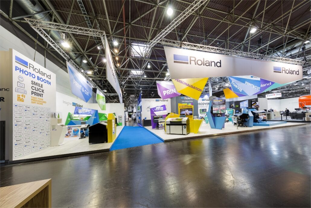 Opgehangen structuren aan het beursplafond duiden in deze beursstand de verschillende zones aan, zodat bezoekers zich goed kunnen oriënteren. beursstand van Roland DG op de beurs Drupa te Dusseldorf