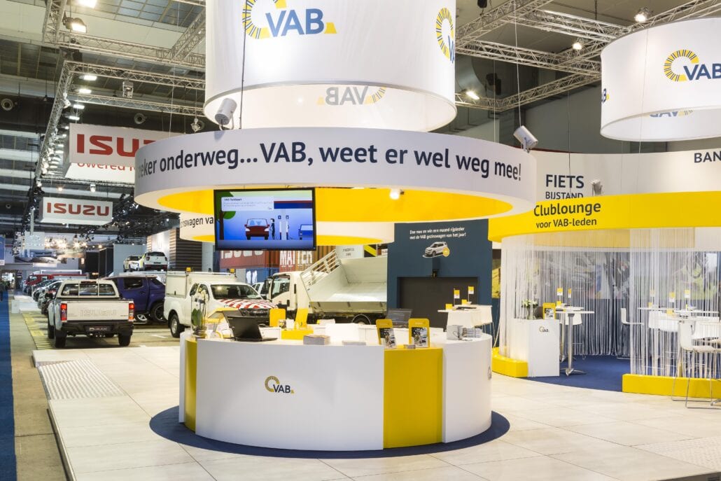 Een uitnodigende ronde infobalie op de beursstand van VAB op het Autosalon van Brussel. De integratie van audio / video materiaal wordt eveneens door Expo Z standenbouw geïntegreerd. ronde vormen op de beursstand van VAB op Autosalon Brussel