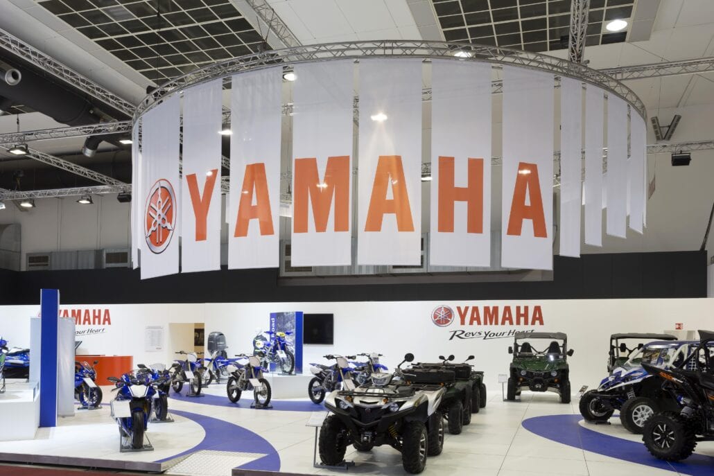 Opgehangen banners geven goed zichtbaarheid aan de beursstand van Yamaha op het Autosalon van Brussel. Ook banners en printwerk verzorgt Expo Z standenbouw in eigen huis. Yamaha beursstand Autosalon Brussel