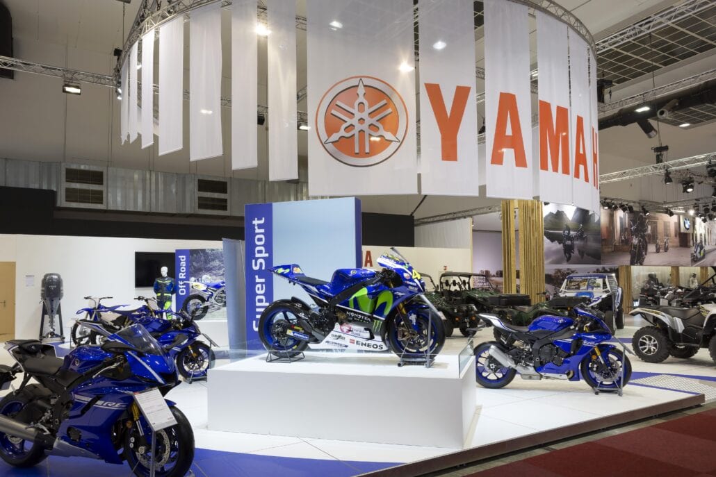 Speciale motoren worden op de stand van het Autosalon in de kijker gezet op een verhoogde sokkel met glazen omranding. beursstand Dieteren Sport Yamaha Autosalon Brussel