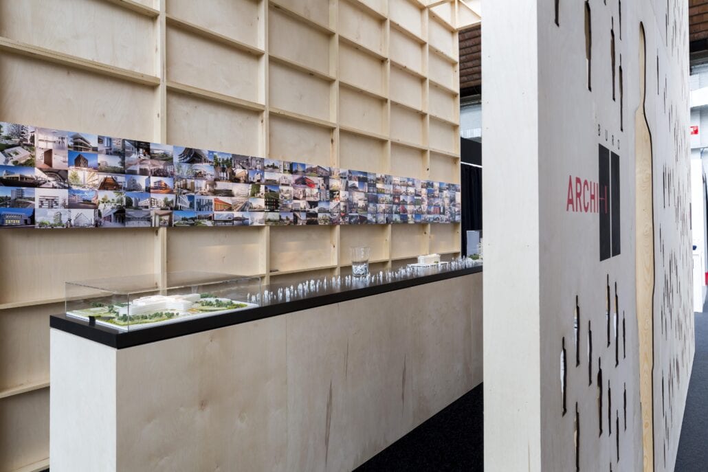Lange balie met maquette en uitgeneden figuurtjes op de beursstand van Buro II te Brussel. Expo Z realiseerde deze creatieve beursstand die eruit springt. architecturale beursstand Brussel