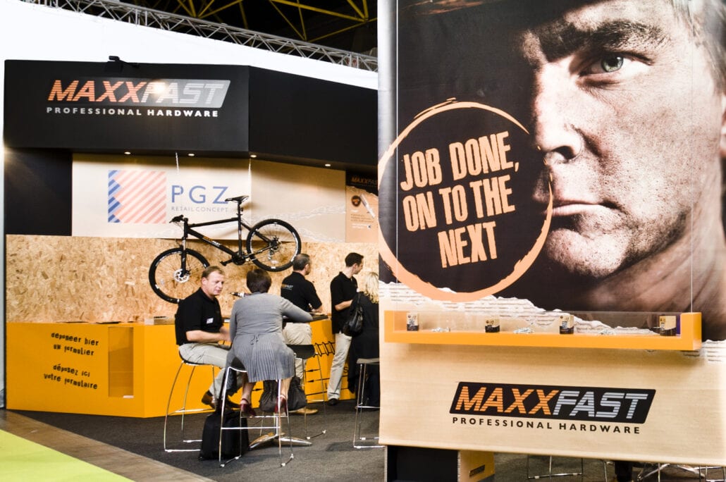 printwerk op groot formaat wordt door Expo Z in eigen huis opgemaakt stoere foto van een werkman geprint op een banner in de beursstand van Maxxfast op DIY Homing te Kortrijk