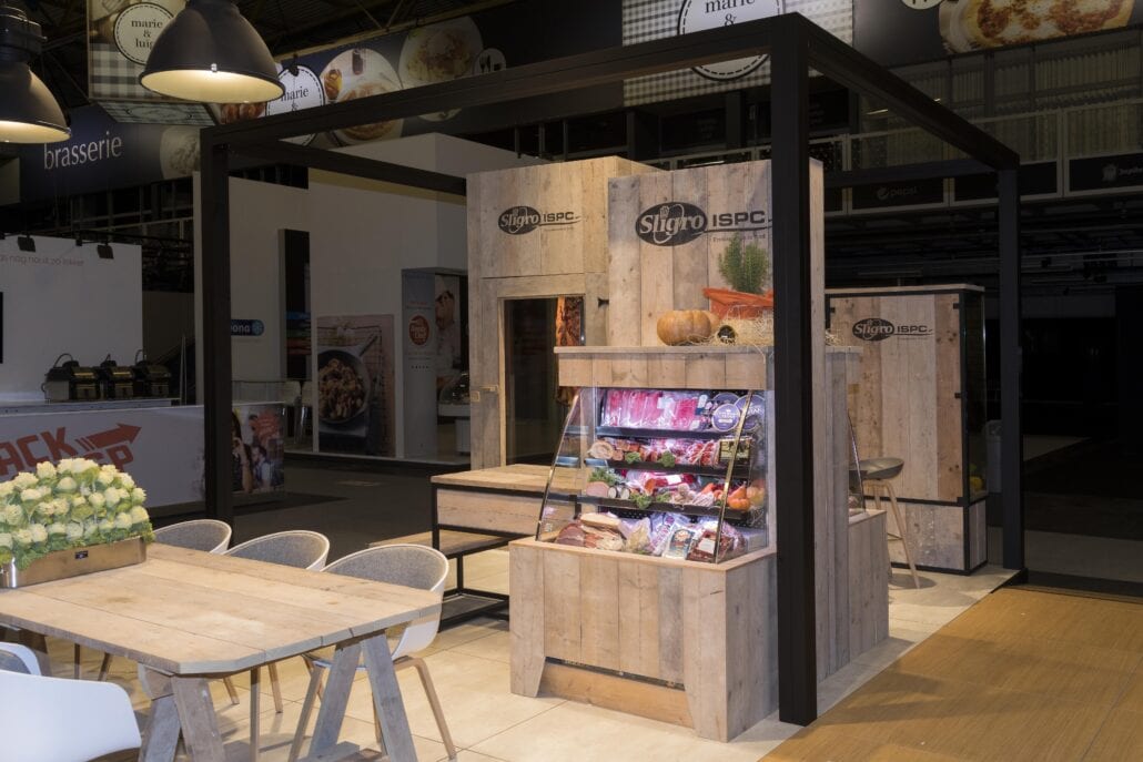 Onze ervaren schrijnwerkers maakten deze steigerhouten meubels op maat voor de klant, met geïntegreerde koelingen en verlichting. op maat gemaakte meubels in steigerhout op beursstand Sligro Horeca Expo