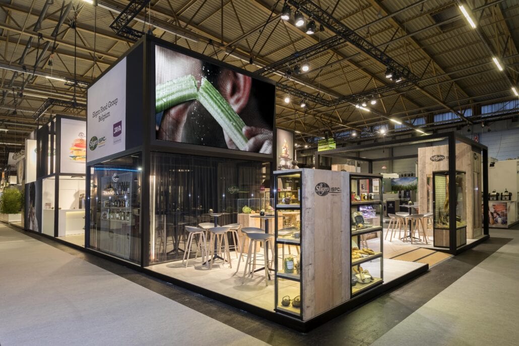 In dit torenelement werd onderaan een spreekruimte met glazen wanden voorzien met daarboven een ingebouwde LED wall. afgesloten glazen spreekruimte op beursstand op Horeca Expo